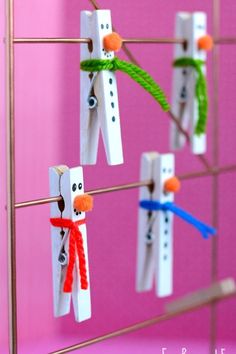 popsicle snowmen are hanging on the clothes pegs