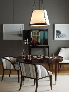 a dining room table with chairs and a lamp hanging from the ceiling in front of it