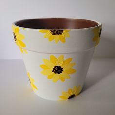 a flower pot with yellow flowers painted on it