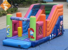 an inflatable bouncer with cartoon characters on it is sitting on a blue tarp