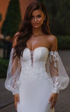 a woman in a wedding dress posing for the camera