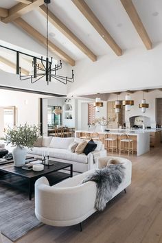 a living room filled with furniture and a chandelier hanging over the top of it