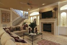 a living room filled with furniture and a flat screen tv mounted on the wall above a fire place