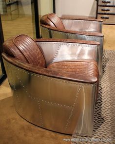 three brown leather chairs sitting next to each other on top of a carpeted floor