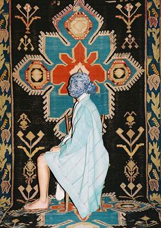 a woman sitting on a chair in front of a rug