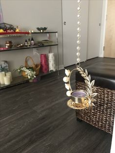 a hanging candle holder in the middle of a room with wood flooring and shelves