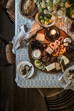 a table topped with lots of different types of cheese and crackers on top of plates