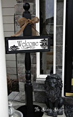 a welcome sign with a lion statue next to it