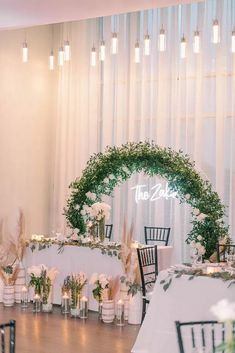 the table is set up with white flowers and greenery for an elegant wedding reception