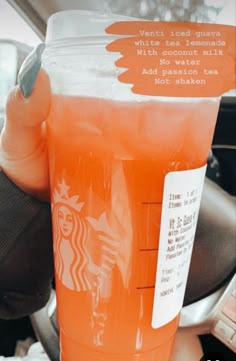 a starbucks drink in a plastic cup sitting on the dashboard of a car with a note attached to it