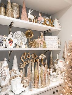 a christmas display in a store with gold and white decorations on shelves, trees, and other holiday items