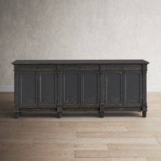 an old black cabinet is sitting on the floor in front of a white wall and wooden floors