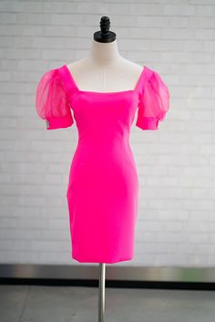 A mannequin in a cocktail dress features puffy semi-sheer cap sleeves with a square neckline and fitted silhouette. Short Sleeve Dresses With Fitted Bodice For Homecoming, Fitted Short Sleeve Dress For Homecoming, Summer Party Dress With Puff Sleeves And Square Neck, Pink Knee-length Puff Sleeve Dress For Party, Short Sleeve Mini Dress With Fitted Bodice For Prom, Fitted Short Sleeve Mini Dress For Prom, Summer Homecoming Mini Dress With Square Neck, Fitted Mini Dress With Square Neck For Homecoming, Summer Evening Puff Sleeve Dress With Sweetheart Neckline