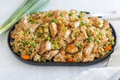 chicken and rice with peas on a black plate