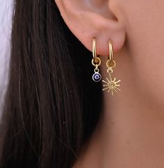 These small hoop earrings are a set of 2 mismatched huggie hoop earrings. The one earring has a evil eye charm on it while the other has a gold charm.  Any combination of hoop is available. Hoops - Gold plated surgical stainless steel Charms - gold plated sterling silver 925 Small Dangle Charm Earrings Silver, Hoop Earrings With Charm, Hoop Earring Set, Piercing Inspo, Boho Hoop Earrings, Sun Charm, Hoops Gold, Small Boho, Hoop Earring Sets