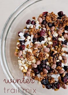 a glass bowl filled with granola, nuts and cranberries