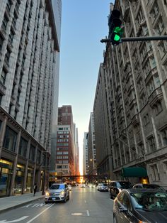 cars are driving down the street in front of tall buildings