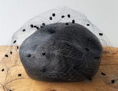 Vintage 1940s (circa 1941) ladies hat designed by much admired French milliner, EVELYN VARON. This exclusive black raffia hat with chenille spots on veil has also a velvet brim to hold in place well with comfort.  Very suitable for Church, a funeral or classy upscale evening wear. Veil is a little torn in areas as shown. MORE ABOUT DESIGNER EVELYN VARON: A March 11, 1914 issue of the Evening Post page of Wanamaker News reported that the Wanamaker Department Store was offering copies of hats designed by Parisian Milliners including Suzanne Talbot, Evelyn Varon, Jeanne Duc, Caroline Reboux and Paul Poiret. The copies that were priced the highest were both of copies of Evelyn Varon designs ($25 and $38). She designed costumes for the 1922 Broadway play "Pins and Needles."   Advertised in Fash Paul Poiret, Raffia Hat, Evening Post, Evening Formal, Black Hat, Costume Design, Department Store, Hat Designs, Evening Wear