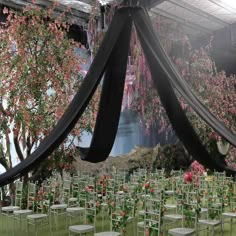 rows of chairs are set up for an outdoor ceremony with pink flowers and greenery