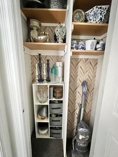 an open closet with shelves filled with dishes and other kitchen items on top of them