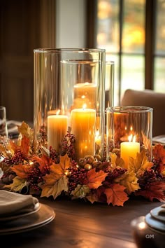 Elegant fall centerpiece with glowing candles, surrounded by autumn leaves, berries, and acorns. Perfect for cozy fall home decor.