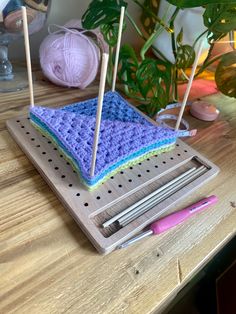 a crocheted dishcloth is sitting on a table with knitting needles and yarn