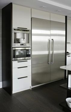 a modern kitchen with stainless steel appliances and white cabinets