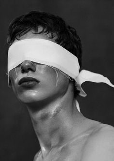 black and white photograph of man with blind folded over his face