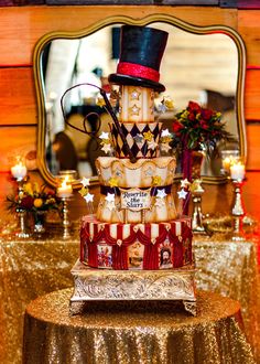 a three tiered cake on top of a table in front of a large mirror