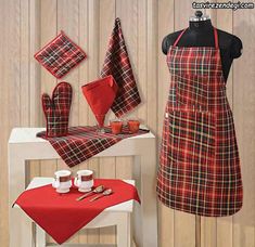 a red and black plaid kitchen set with matching aprons, pot holders, teacups and napkins