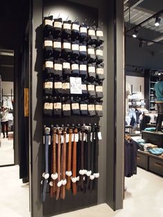 a display case filled with lots of different types of belts and ties hanging on the wall