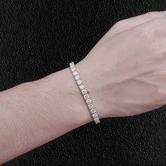 Dazzle your friends, with this stunning moissanite tennis bracelet. The stones are moissanite, which shine even brighter than diamonds, and although it ain't cheap, it costs a tiny fraction of it's diamond equivalent. You can literally look like a millionaire, without having to be one! The two stone sizes (4mm & 5mm) we have are the sizes men wear. Smaller and they are too dainty. Larger and they again take on a more feminine look. Of these two sizes, most guys go for the 5mm. They are set in a Diamond White Sterling Silver Bracelet With Cubic Zirconia, Diamond White Cubic Zirconia Tennis Bracelet With Jubilee Style, Diamond White Cubic Zirconia Tennis Bracelet With Jubilee Design, White Cubic Zirconia Jubilee Sterling Silver Bracelet, Adjustable Diamond White Tennis Bracelet With Jubilee Style, Diamond White Moissanite Jubilee Bracelet, Minimalist Cubic Zirconia Tennis Bangle Bracelet, White Cubic Zirconia Round Cut Bracelet, White Gold Moissanite Jubilee Bracelet