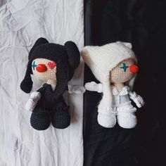 two crocheted dolls are laying on a sheet