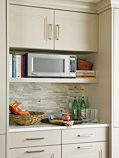 a microwave oven sitting on top of a kitchen counter next to cupboards filled with food