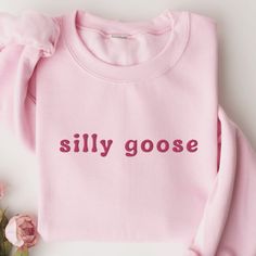 Silly Goose Sweatshirt, Embroidered Goose Crewneck Sweatshirt, Silly Goose Shirt, Funny Sweatshirt, Funny Embroidered Shirt This embroidered silly goose crewneck sweatshirt is everything. Perfect to tell everyone that you're a silly goose. Please let me know if you would like extended sizing (3X-5X), I have certain color and size options available! ✨ 50% cotton, 50% polyester ✨ Pre-shrunk ✨ Classic fit Care: Machine wash: warm (max 40C or 105F) Tumble dry: low Do not iron directly on the print About me: My name is Sarah and I am a graduate student and music teacher! I run this small business myself and enjoy creating fun designs in my free time for some extra cash. I hope that you enjoy these designs as gifts for others or even yourself! REFUNDS AND EXCHANGES All items are made to order us Trendy Long Sleeve T-shirt With Embroidered Logo, Trendy Long Sleeve Top With Embroidered Logo, Trendy Embroidered Long Sleeve T-shirt, Trendy Long Sleeve Embroidered T-shirt, Trendy Cotton Sweater With Letter Embroidery, Casual Pink Sweater With Embroidered Logo, Pink Cotton Sweater With Text Print, Trendy Long Sleeve T-shirt With Embroidered Text, Trendy Long Sleeve Top With Letter Embroidery