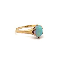 a gold ring with an opal stone in the center