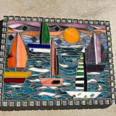 a glass mosaic with boats and oranges on it