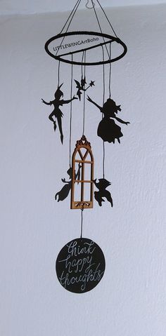 a black and white photo of a wind chime with tinkerbells hanging from it