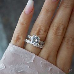 a close up of a person's hand with a diamond ring on their finger