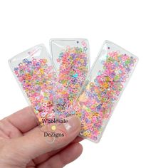 three clear plastic bags filled with colorful sprinkles on top of each other