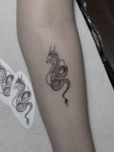 a black and white photo of a snake tattoo on the arm