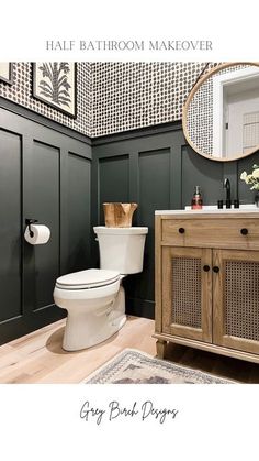 a white toilet sitting next to a wooden cabinet in a bathroom under a round mirror