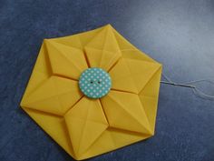 an origami piece with a button on it