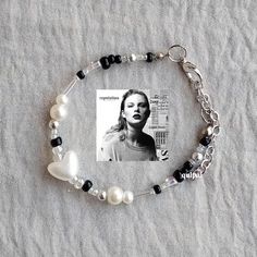 a bracelet with a photo and pearls on the clasp is laying on top of a sheet of fabric