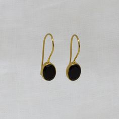 Black Onyx and 18k Gold Vermeil Oval Drop Earrings Natural cabochon black onyx gemstones in a simple 18k gold plated silver setting, with a hook fitting. Simple drop earrings perfect for everyday wear.  Dimensions (approx): * Length: 2.2cm including hook * Turquoise: 7mm x 9mm Materials: * 18k Gold Plated Silver * Black Onyx Beyond Biasa creates unique jewellery that is inspired by antique and tribal designs from around the globe. All of our pieces are handmade so please allow for slight variati Elegant Oval Cabochon Earrings With Polished Finish, Classic Black Earrings With Polished Finish, Classic Oval Cabochon Gemstone Earrings, Minimalist Gemstone Earrings For Formal Occasions, Classic Black Oval Earrings, Formal Onyx Gemstone Earrings, Black Oval Earrings For Formal Occasions, Polished Onyx Earrings For Gift, Classic Round Onyx Earrings