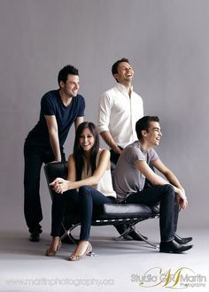 three people sitting on a bench posing for the camera