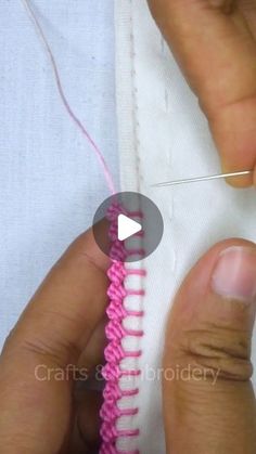 someone is stitching the end of a piece of pink thread with a pair of scissors