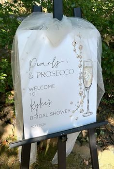 a welcome sign with a glass of wine on it for the bride and groom to arrive