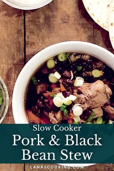 slow cooker pork and black bean stew in a white bowl on a wooden table