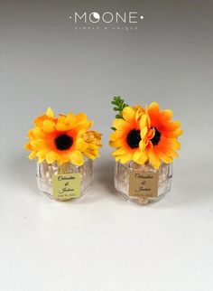 two small vases with sunflowers in them